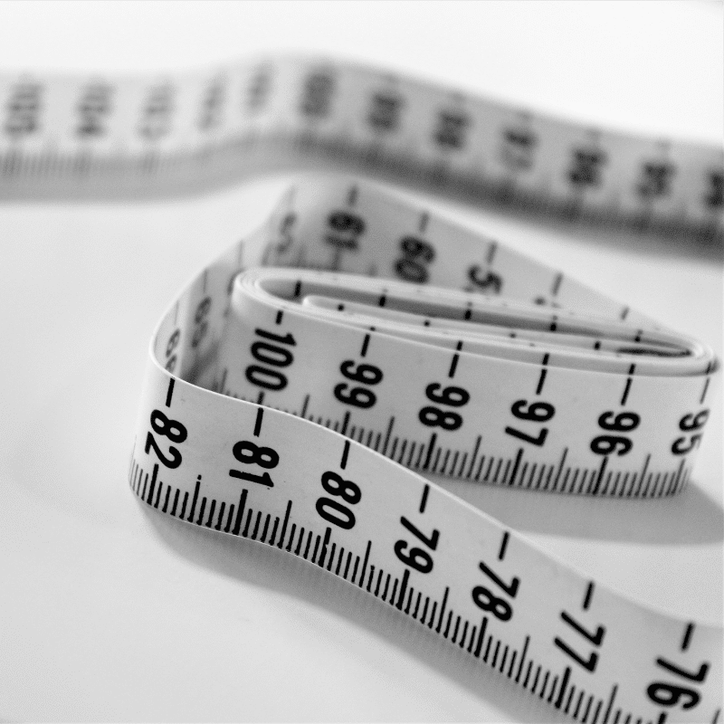 A measuring tape on a white surface, used for weight loss surgery.